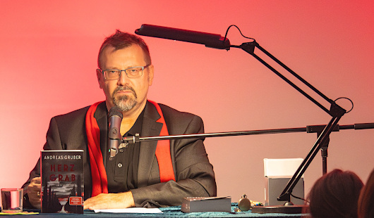 Autor Andreas Gruber an einem Schreibtisch während der veranstaltung Lesestadt Oberhausen