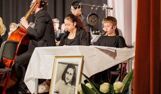 Podiumsausschnitt mit einem Bild der Anne Frank. (Foto: Dominik Schneider)