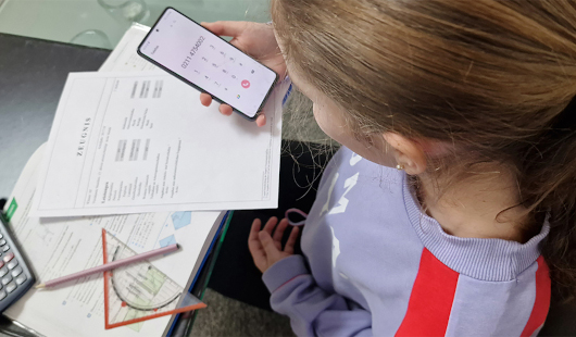 Mädchen mit Zeugnis und Telefon