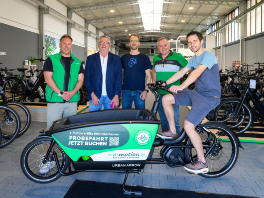 In der e-motion e-bike Welt überreichten Geschäftsführer Erol Yesilbas (l.) und Inhaber Karl-Josef Pinger (4.v.l.) das E-Lastenrad an den STADTRADELN-Star Sören Schulte (r.). Von der Stadt Oberhausen begrüßten Markus Werntgen-Orman (2.v.l, Leiter des Bereichs Umwelt) und Clemens Printz (3.v.l., lokaler STADTRADELN-Koordinator) diesen Einsatz für nachhaltige Mobilität. (Foto: Stadt Oberhausen/Tom Thöne)