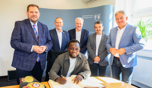 Interimsboxweltmeister Abbas Baraou, dahinter v. li.: Oberbürgermeister Daniel Schranz, Manfred Gregorius, Vorsitzender des Stadtsportbundes, Christian Meyer, Promoter, Robert Babic, Vorsitzender des Sportausschusses, und Jürgen Schmidt, Beigeordneter. (F