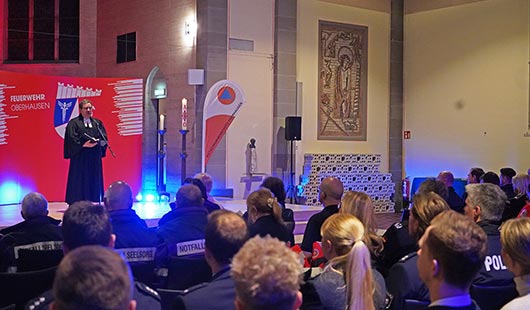 Teilnehmerinnen und Teilnehmer des Gottesdienst folgen den Worten des Geistlichen. Foto: Feuerwehr Oberhausen