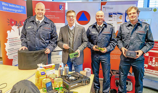 Martin Götzke, Fachbereichsleiter Zivil- und Katstrophenschutz, Michael Jehn, für die Feuerwehr zuständiger Beigeordneter, Jörg Brandenburg, Bereichsleiter Feuerwehr und Dominik Steger, stellvertretender Feuerwehrbereichsleiter, erklären, welche Dinge zum Notvorrat zählen. (Foto: Stadt Oberhausen/Tom Thöne)