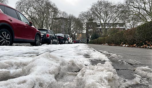 Bürgersteige: links noch mit Schnee, rechts im Bild von Schnee befreit