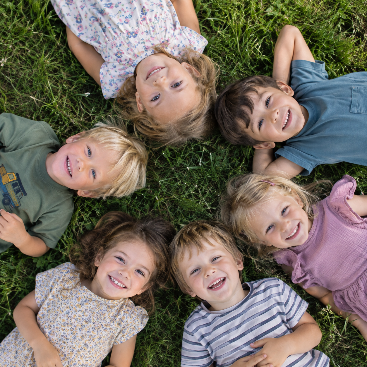 Foto: Kinder liegend in der Wiese (Quelle: ChatGPT (AI Generated))