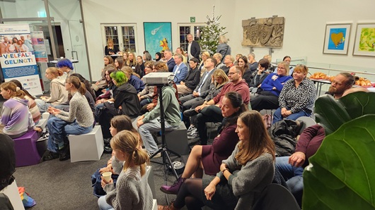 Menschengruppe sitzt in einem großen Raum