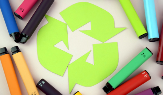 bunte Einwegvapes sowie das Recyclingzeichen (Foto: Adobe Stock/iama_sing)