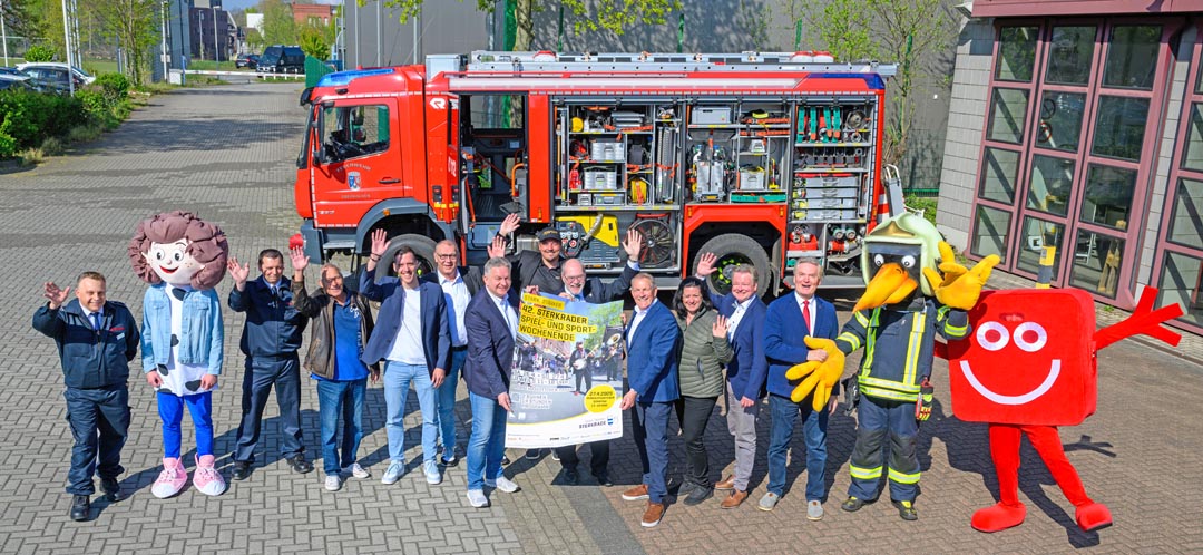 Einige Maskottchen, Vertreterinnen und Vertreter der Sponsoren, der STIG, des SSB und des städtischen Veranstaltungsmanagements präsentieren das Plakat zum 42. Sterkrader Spiel- und Sportwochenende. (Foto. Stadt Oberhausen, Tom Thöne)