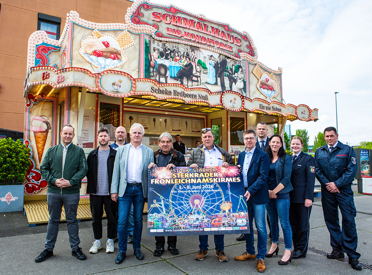 Die Vertreterinnen und Vertreter der Schaustellerbetriebe, der Stadt Oberhausen, von Feuerwehr und Polizei hoffen wieder auf zahlreiche Besucherinnen und Besucher der diesjährigen Sterkrader Fronleichnamskirmes. In der vorderen Reihe am Plakat v.l. Bodo Nößler (Bereich Öffentliche Ordnung), Rudolf „Ronny“ Schütze (Verein Reisender Schausteller Oberhausen), Peter Buchholz (Verein Reisender Schausteller Oberhausen) und Dezernent Michael Jehn. (Foto Stadt Oberhausen/Carsten Walden)